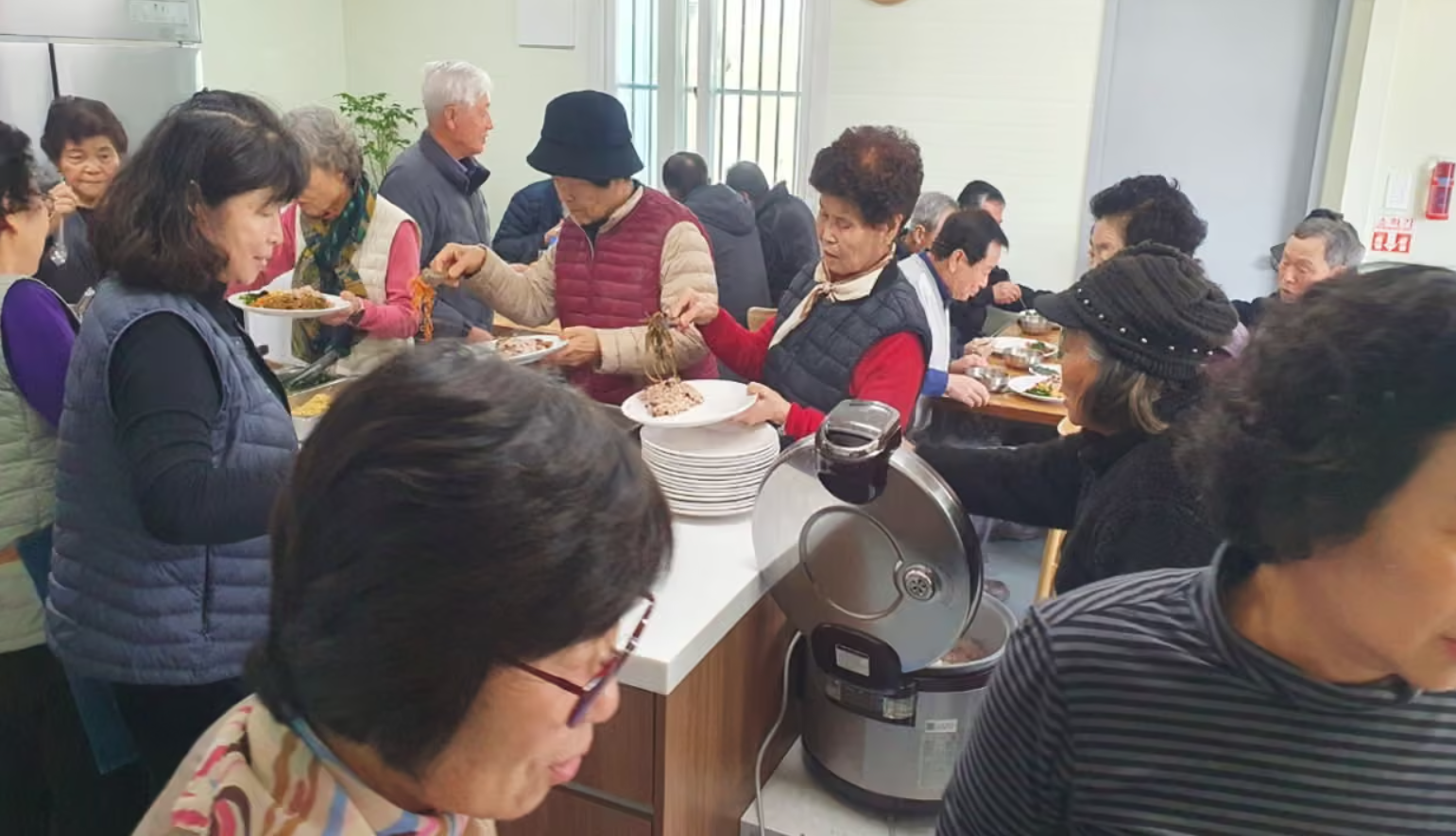 Người dân làng Guyang-ri dùng bữa miễn phí - một trong những phúc lợi cộng đồng được tài trợ từ nguồn thu điện mặt trời của làng. Ảnh: The Guardian
